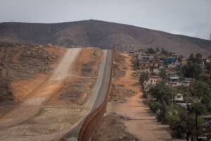 USA, San Diego, 2019-11-20. Border Patrol agent patrols along a section of the U.S.-Mexico border fence. Photograph by F