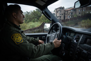 USA, San Diego, 2019-11-20. Border Patrol agent patrols along a section of the U.S.-Mexico border fence. Photograph by F