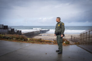 USA, San Diego, 2019-11-20. Border Patrol agent patrols along a section of the U.S.-Mexico border fence. Photograph by F