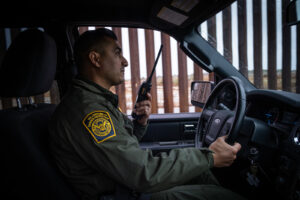 USA, San Diego, 2019-11-20. Border Patrol agent patrols along a section of the U.S.-Mexico border fence. Photograph by F