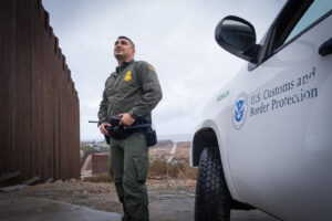 USA, San Diego, 2019-11-20. Border Patrol agent patrols along a section of the U.S.-Mexico border fence. Photograph by F