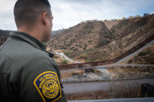 USA, San Diego, 2019-11-20. Border Patrol agent patrols along a section of the U.S.-Mexico border fence. Photograph by F