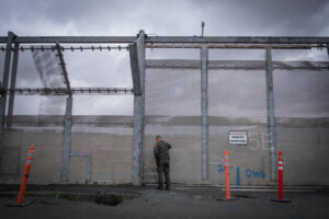 USA, San Diego, 2019-11-20. Border Patrol agent patrols along a section of the U.S.-Mexico border fence. Photograph by F
