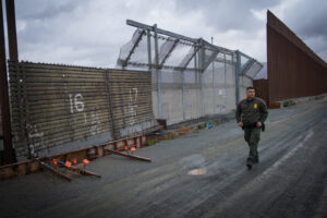 USA, San Diego, 2019-11-20. Border Patrol agent patrols along a section of the U.S.-Mexico border fence. Photograph by F