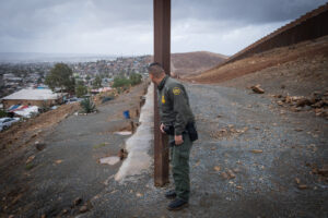 USA, San Diego, 2019-11-20. Border Patrol agent patrols along a section of the U.S.-Mexico border fence. Photograph by F