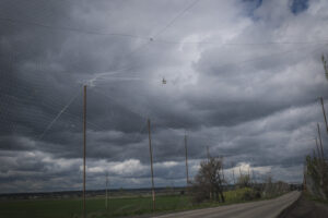 Ukraine, Pavlograd, 2026-04-24. Kilometres of netting strung on poles turn the supply roads of the Ukrainian rear into c