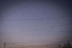 Ukraine, Pavlograd, 2026-04-25. Kilometres of netting strung on poles turn the supply roads of the Ukrainian rear into c